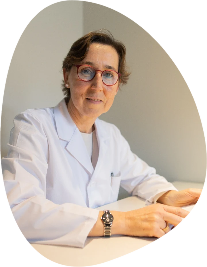 Inma Ferrer, médico psicoterapeuta especialista en duelo, sentada a una mesa con bata blanca